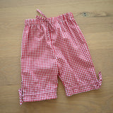 Red and white gingham pants on a wooden surface